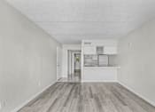 Thumbnail 8 of 14 - A kitchen with white cabinets and a wooden floor.