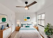 Thumbnail 12 of 49 - A bedroom with a bed, nightstands, and a ceiling fan.