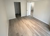 Thumbnail 11 of 23 - A room with a ceiling fan and a wooden floor.