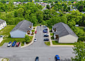 Thumbnail 23 of 30 - A parking lot with cars and two houses.