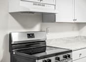 Thumbnail 17 of 29 - A modern kitchen with a stainless steel oven and white cabinets.