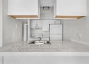 Thumbnail 4 of 14 - A kitchen with white cabinets and a marble countertop.