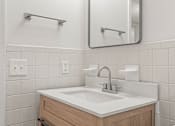 Thumbnail 9 of 28 - A bathroom sink with a white counter top and a wooden drawer.