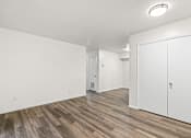 Thumbnail 16 of 29 - A room with a white wall and a wooden floor.