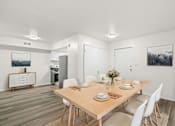 Thumbnail 1 of 29 - A dining room with a wooden table and white chairs.