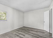 Thumbnail 13 of 14 - A room with a wooden floor and a window.