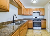 Thumbnail 7 of 16 - A kitchen with wooden cabinets and a stainless steel dishwasher.