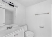 Thumbnail 14 of 14 - A white bathroom with a toilet, sink, mirror, and towel bar.