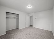 Thumbnail 9 of 16 - A sparsely furnished room with a closet and a door.