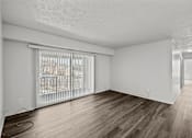 Thumbnail 11 of 29 - A room with wooden flooring and white walls.