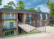 Thumbnail 24 of 29 - A brick building with a balcony and a metal railing.