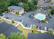 Thumbnail 29 of 29 - A parking lot with a pool and a building in the background.