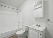 Thumbnail 31 of 41 - A white bathroom with a toilet, sink, and bathtub.