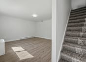 Thumbnail 26 of 41 - A room with a staircase and a light on the ceiling.