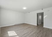 Thumbnail 25 of 41 - A room with a white wall and a wooden floor.
