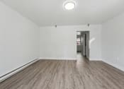 Thumbnail 27 of 41 - A room with wooden flooring and white walls.