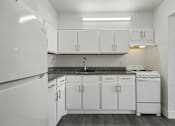 Thumbnail 14 of 41 - A kitchen with white cabinets and appliances.