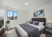 Thumbnail 7 of 41 - A bedroom with a large bed and a window overlooking a residential area.