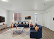 Thumbnail 3 of 41 - A living room with a blue couch and a coffee table.