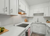 Thumbnail 13 of 41 - A kitchen with white cabinets and a cutting board with green apples on it.