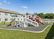Thumbnail 57 of 65 - A playground with a red slide and white fence.