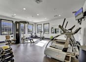 Thumbnail 36 of 55 - A gym with a variety of equipment including a treadmill, weights, and exercise machines.