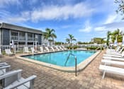 Thumbnail 24 of 26 - A pool surrounded by lounge chairs and palm trees.
