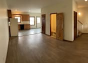 Thumbnail 1 of 53 - A spacious living room with wooden floors and furniture.