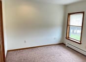 Thumbnail 9 of 53 - A room with a window and a carpeted floor.