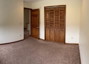 Thumbnail 10 of 53 - A room with a brown carpet and a brown door.