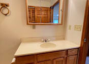 Thumbnail 30 of 53 - A bathroom with a sink and a mirror with lights on it.