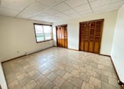 Thumbnail 20 of 53 - A room with a tiled floor and a window with wooden shutters.