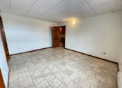 Thumbnail 21 of 53 - A room with a tiled floor and a wooden door.