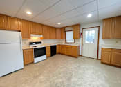 Thumbnail 16 of 53 - A kitchen with wooden cabinets and a white refrigerator.