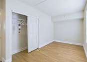 Thumbnail 10 of 16 - A room with a white door and a wooden floor.