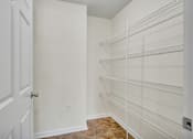 Thumbnail 20 of 55 - A white door is open to a room with a white wall and a white shelving unit.