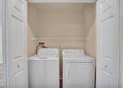 Thumbnail 22 of 55 - A small laundry room with a washer and dryer.