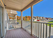 Thumbnail 23 of 55 - A balcony with a metal railing and a wooden floor.