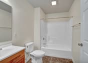 Thumbnail 27 of 55 - A white toilet sits next to a sink in a small bathroom.