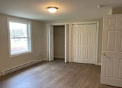 Thumbnail 17 of 49 - A room with a white door, a window, and a light on the ceiling.