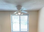 Thumbnail 31 of 49 - A room with a ceiling fan and a window with blinds.