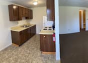 Thumbnail 22 of 49 - A kitchen with brown cabinets and a white countertop is shown.
