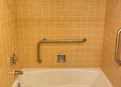 Thumbnail 23 of 49 - A white bathtub with a silver faucet and a silver grab bar.