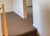 Thumbnail 32 of 49 - A hallway with a carpeted floor and a white door.