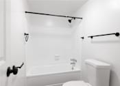 Thumbnail 16 of 26 - a white bathroom with a white toilet and a tub and a shower curtain