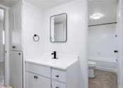 Thumbnail 17 of 26 - a white bathroom with a sink and a mirror
