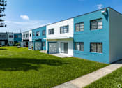Thumbnail 17 of 25 - a row of blue and white houses on a green lawn