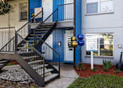Thumbnail 16 of 18 - the front of a building with stairs and a sign in front of it