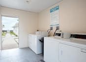 Thumbnail 9 of 12 - a laundry room with two washing machines and a door to the beach