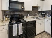 Thumbnail 6 of 11 - a kitchen with black appliances and white cabinets
